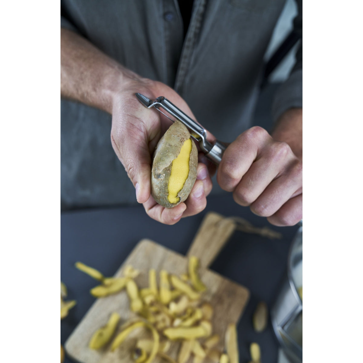 Personne épluchant une pomme de terre avec l'éplucheur pivotant ZWILLING Pro