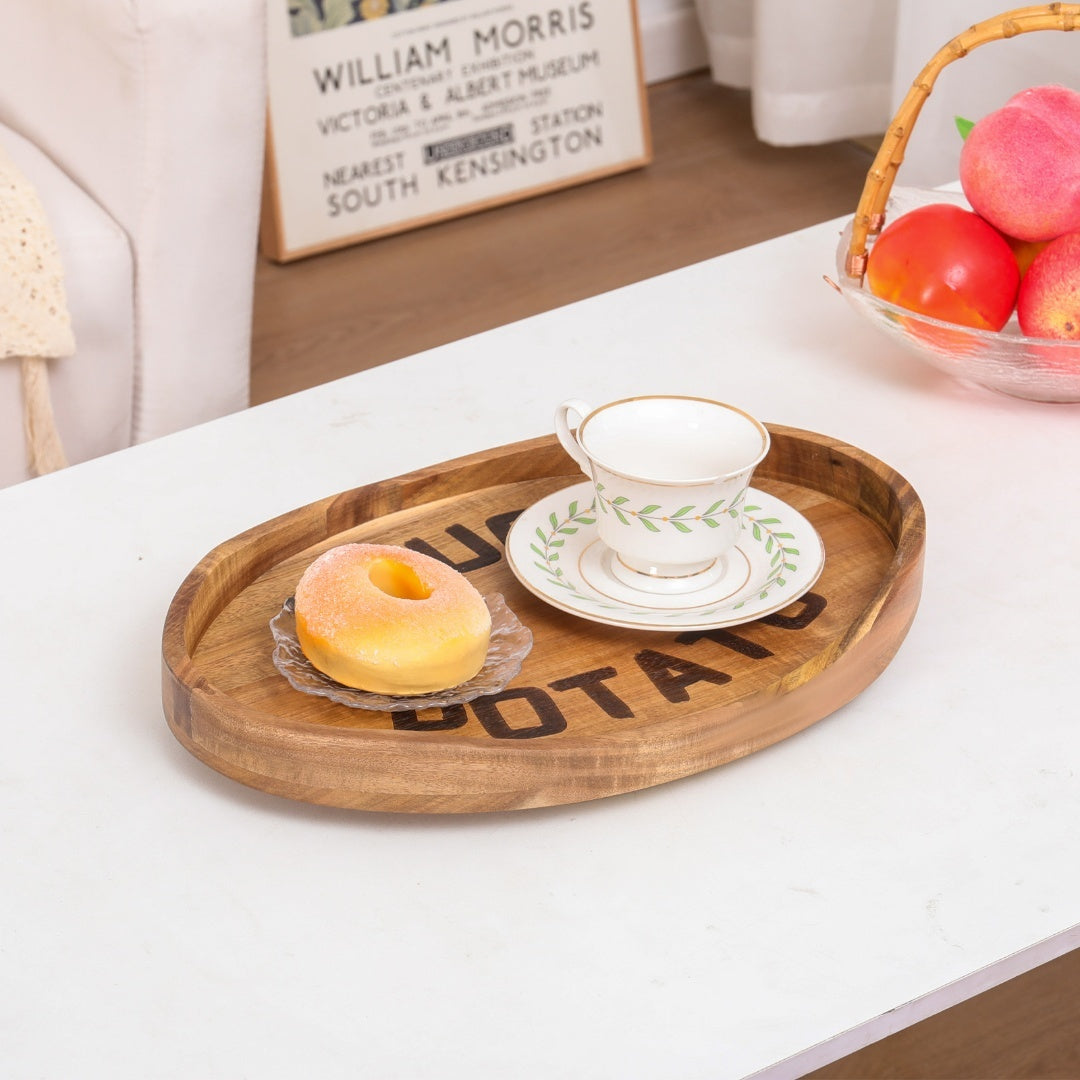 Plateau en bois d'acacia sur une table basse avec tasse de thé et beignet