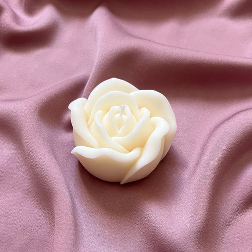 Bougie rose blanche en cire de soja sur un tissu rose
