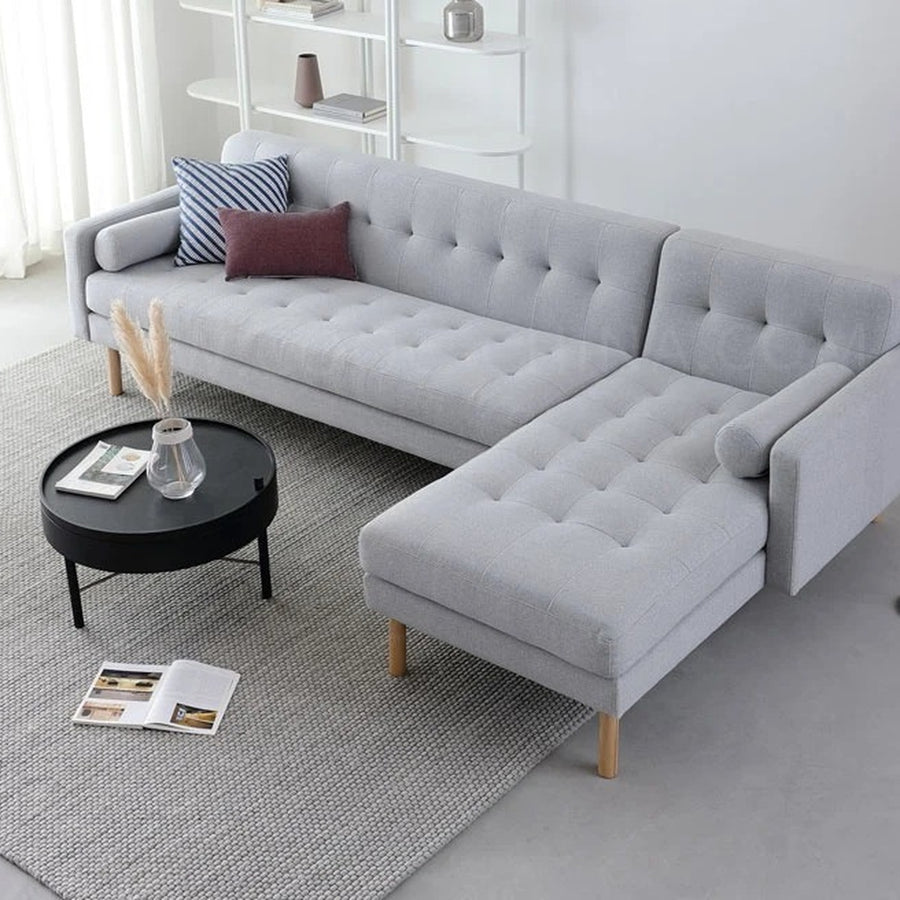 Canapé sectionnel nordique gris en L avec chaise longue et coussins, dans un salon moderne