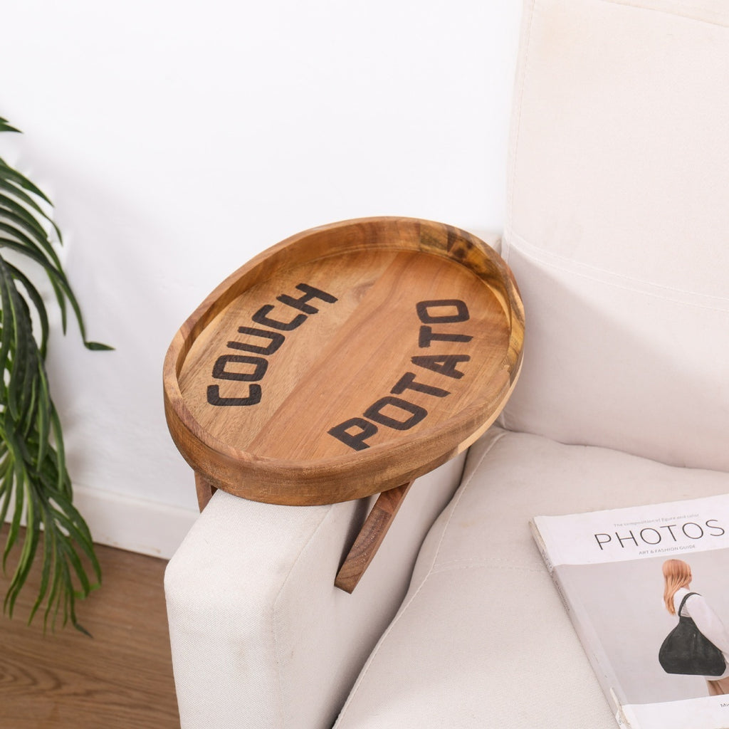 Plateau rond en bois d'acacia fixé à l'accoudoir d'un canapé blanc