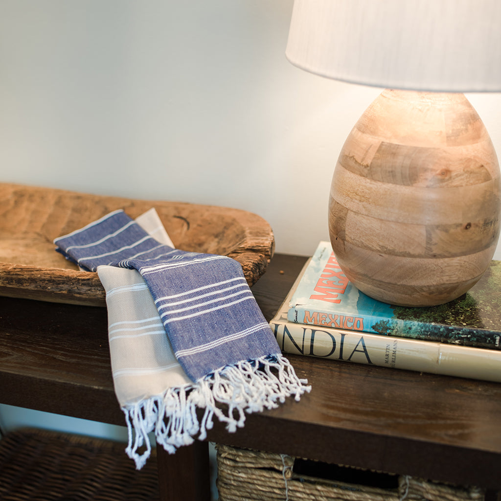 Essuie-mains turcs bleu et beige posés sur une table en bois