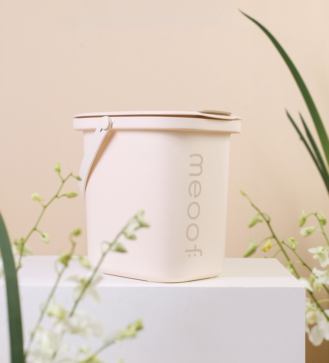 Contenant sous vide couleur crème sur un piédestal avec des fleurs