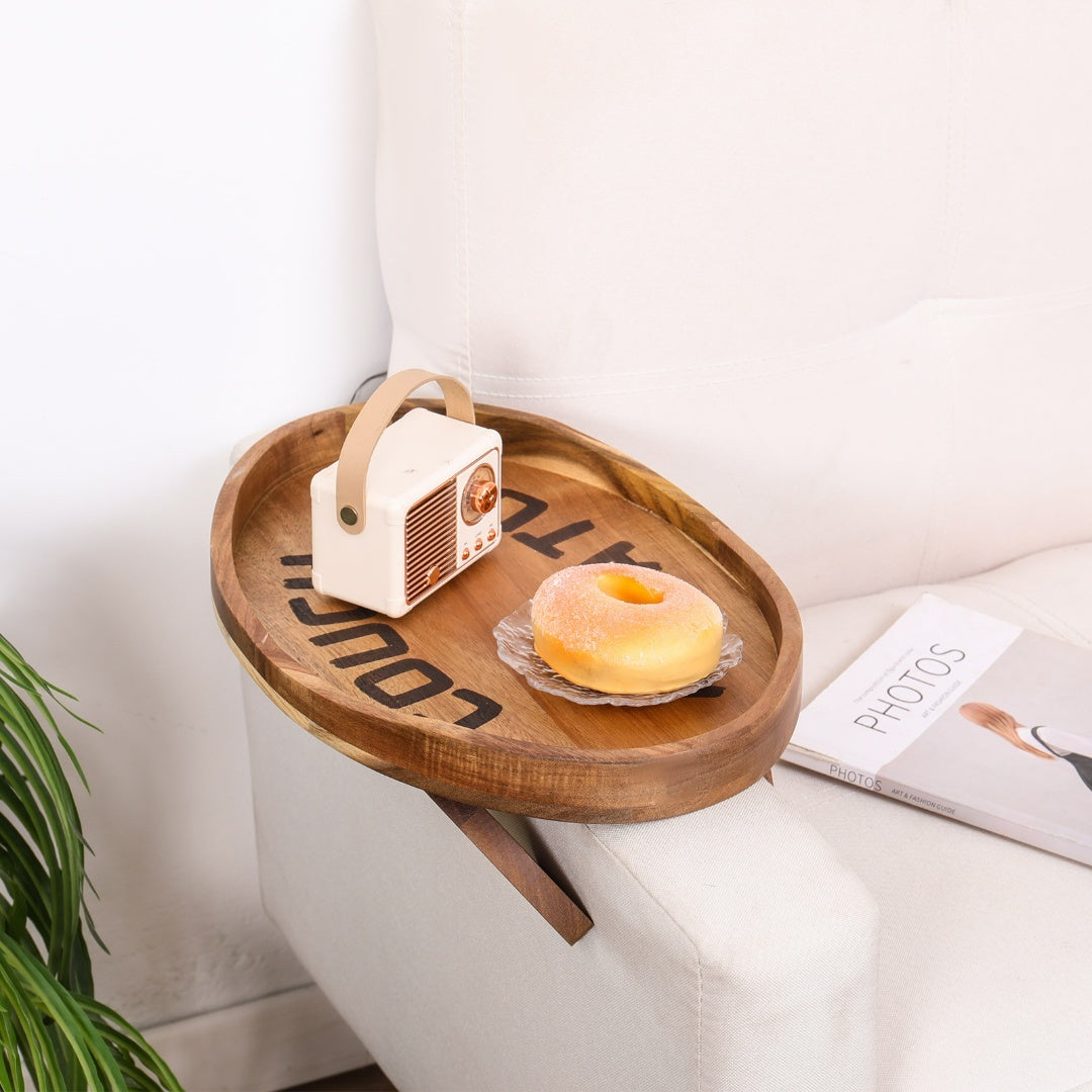 Plateau en bois d'acacia sur un accoudoir de canapé avec radio et beignet